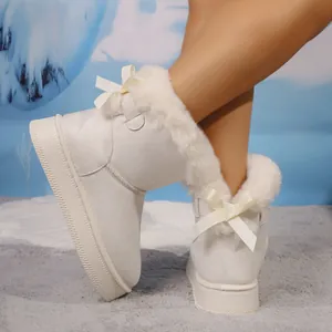 Detailed view of white women's winter snow boots featuring plush lining and decorative bow