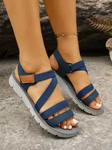 Close-up of retro cross-strap flat sandals worn outdoors for a summer beach look