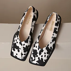 Vista detallada de zapatos planos con estampado de vaca, punta cuadrada y escote en V