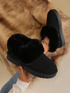 Close-up detail of women black snow boots with plush faux fur collar and suede finish
