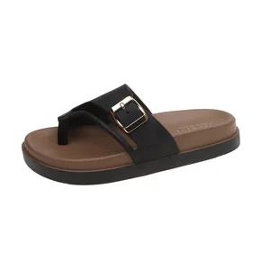Detailed view of women's black and brown platform slide with golden buckle detail.