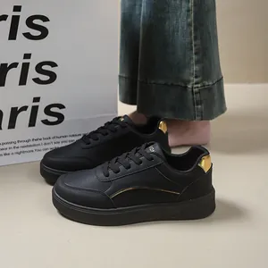 Detailed side view of black low-top platform sneakers with gold accents and round toe