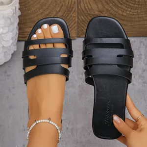 Detailansicht der schwarzen flachen Damen-Sandalen mit modischem Cut-out-Riemendesign.
