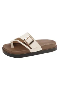 Detail view of women's cream platform flip-flops with buckle and brown footbed.