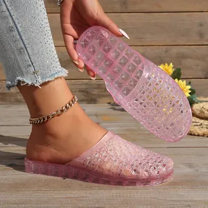 Close-up detail of pink glitter jelly sandals featuring a breathable hollow-out woven design