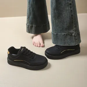 Detail view of black thick-sole women's sneakers styled with denim jeans.
