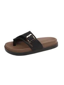 Close-up of black platform flip-flop sandal with decorative buckle and brown footbed.