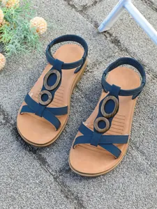 Detailed view of navy blue women's flat Roman sandals with vintage wooden circle accents