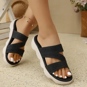 Close-up of comfortable women's black knit flat sandals with white thick platform soles.