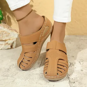 Schicke braune flache Pantoletten für Damen mit Laser-Cut-Details und Urlaubsstil.