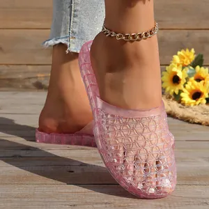 Detailed macro view of pink translucent hollow-out crystal mesh slippers on wooden deck