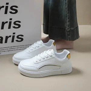 Detail shot of white platform sneakers with gold accents and lace-up closure