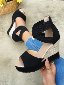 Macro detailed view of black suede wedge sandals with cross elastic ankle straps