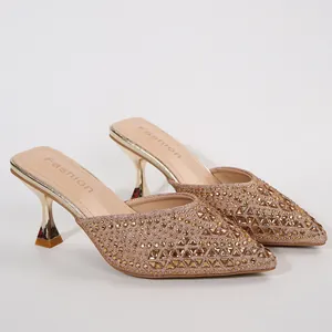 Close-up of champagne rhinestone pointed-toe mules with shimmering crystal details