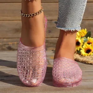 Macro detail of pink crystal jelly slippers featuring a breathable hollow lattice design