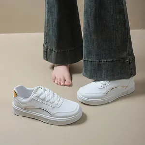 Detailed view of women's thick-soled white sneakers with gold accents and casual style.