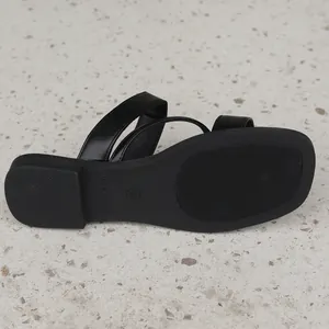 Macro view showing the non-slip sole texture and size 37 mark of the black flat sandal.