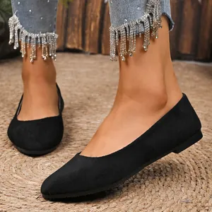 Vista dettagliata delle ballerine a punta in camoscio nero indossate con i jeans
