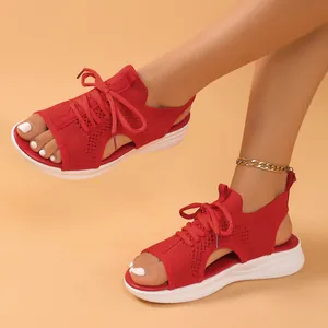 Close-up of red knit sports sandals featuring lace-up design and thick white sole