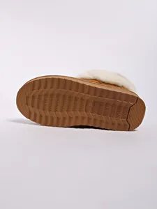 Detailed macro view of the textured non-slip rubber sole on a tan winter snow boot