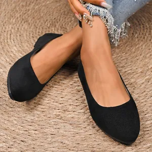 Primo piano di scarpe ballerine nere in camoscio a punta su una modella elegante