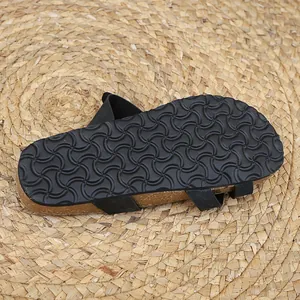 Detailed view of the non-slip wave pattern sole on black cork flat summer slippers