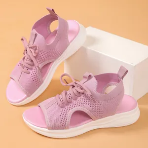 Close-up of pink fly-knit sports sandals with thick white soles and breathable hollow design
