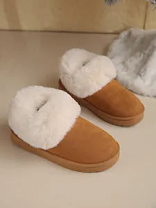Detail view of chestnut snow boots featuring plush white faux fur collars and flat soles.