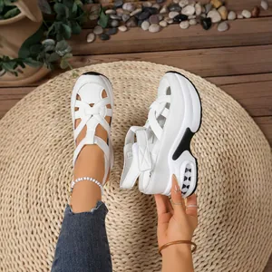 Stylish white platform sandals with hollow-out design and velcro straps for summer.