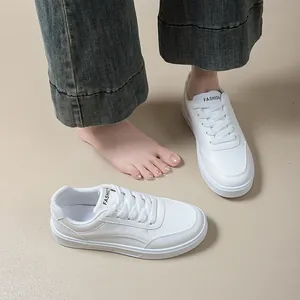 Close-up of minimalist white low-top sneakers with a thick sole and round toe