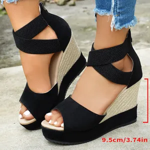 Close-up detail showing the 9.5cm heel height on black suede peep-toe wedge sandals.