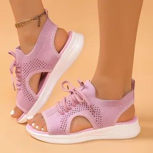 Side view of pink fly-knit sports sandals with thick white soles and hollow design