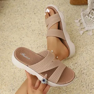 Detailed view of women's beige flyknit slide sandals featuring a thick white wavy sole