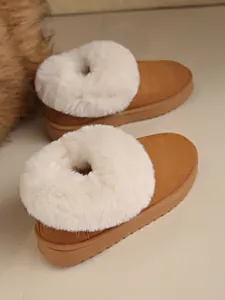 Close-up view of cozy brown suede snow boots featuring a white fluffy fur collar design