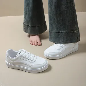 Close-up of white women's platform sneakers featuring minimalist round toe design