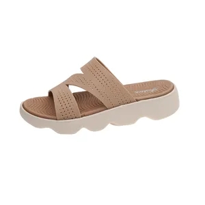Detail view of casual beige fly-knit slides with comfortable wavy platform sole