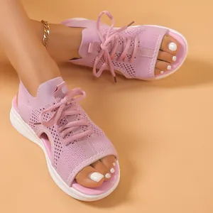 Detail of pink fly-knit sports sandals with thick white soles and open-toe design