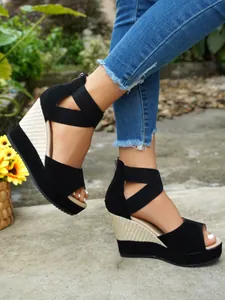 Close-up of stylish black suede wedge sandals with thick platform and peep-toe design
