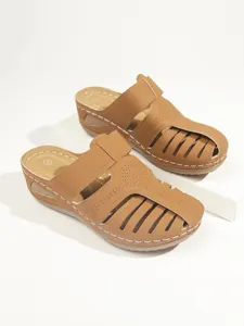 Detailansicht brauner Damen-Keilpantoletten mit eleganten weißen Kontrastnähten