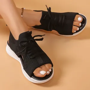 Detail view of black breathable fly-knit platform sports sandals for women on model