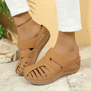 Nahaufnahme von stilvollen braunen geschlossenen flachen Mules mit Cut-out-Design für Damen