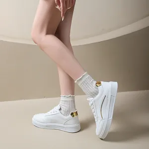 Elegant white platform sneakers for women featuring stylish gold heel accents and a lace-up design
