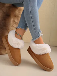 Detail view of women's warm snow boots with white faux fur trim and camel suede upper