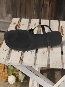 Détail de la semelle en caoutchouc noir antidérapante d'une sandale plate pour femme
