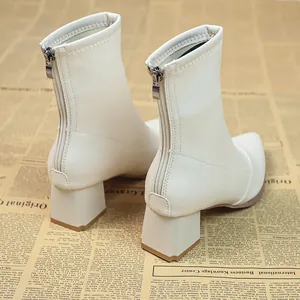 Detailansicht der weißen spitzen Stiefeletten mit klobigen Blockabsätzen und Reißverschluss