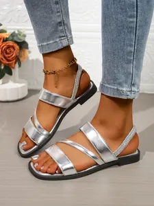 Detailansicht silberner flacher Sandalen mit Riemchen im Römer-Stil für den Sommer