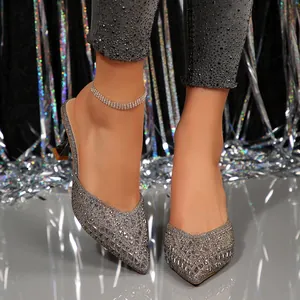 Close-up of sparkly silver pointed-toe mule heels with rhinestone studs for party wear
