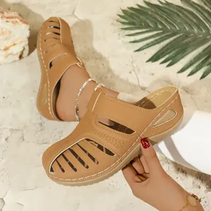 Stilvolle hellbraune Mules für Damen mit Cut-Out-Design auf sandigem Strandhintergrund