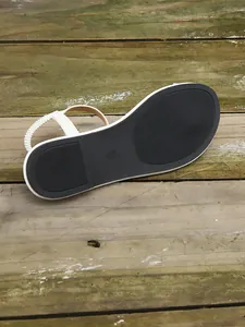 Bottom view of white flat sandals showing anti-slip black rubber sole with size 37