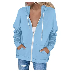 Front view of a light blue women's zip-up drawstring hoodie with pockets on a model.